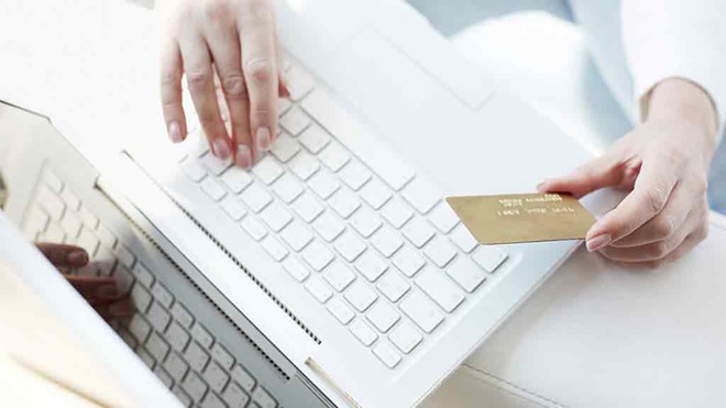 person holding credit card with computer